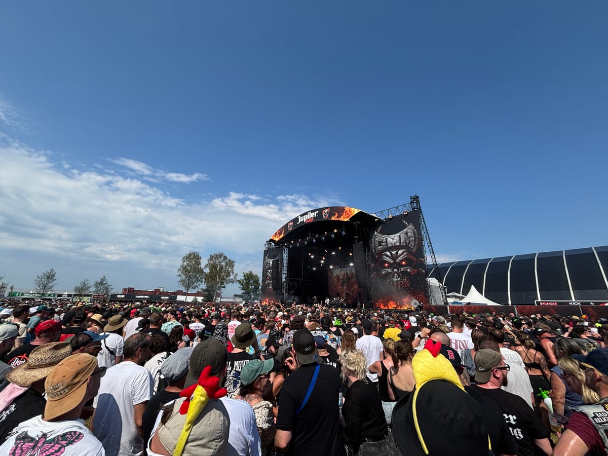 Attendees of a music festival, immersed in the performance, surrounded by colorful banners and a lively atmosphere.